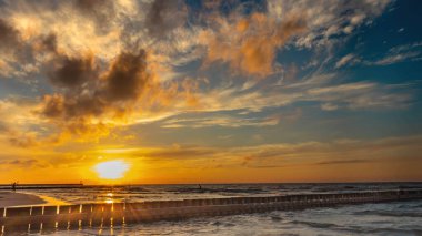 Yaz boyunca Polonya Denizi üzerinde batan güneşe karşı dalgalı su