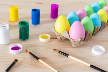 Paskalya yumurtaları ve renkli boyalar tatil için masanın üstünde..
