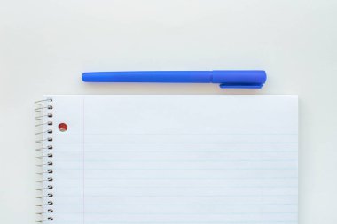 Çizgili boş defter ve kalem. Spiral not defteri ve mavi kalem. Okul malzemeleri.