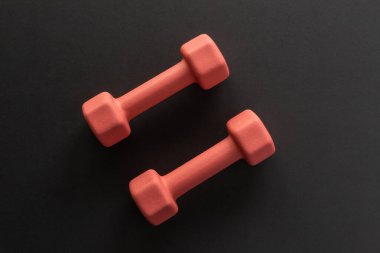 Siyah arka planda dambıllar. Fitness, spor ve spor konsepti düzleştirildi. Kopyalama alanı ile ağırlık düzeni