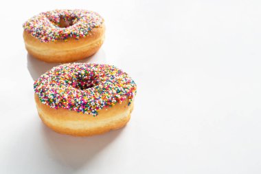 Beyaz arka planda renkli serpiştirilmiş donut. Metin için kopyalama alanı olan yüksek açı görünümü.