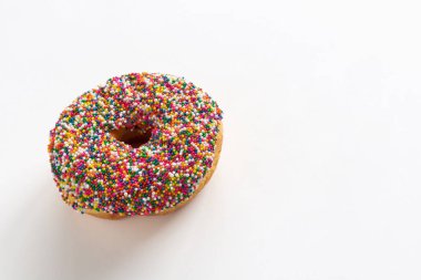 Beyaz arka planda renkli serpiştirilmiş donut. Metin için kopyalama alanı olan yüksek açı görünümü.