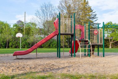 Kanada 'nın Ottawa kentindeki halk parkındaki çocuklar için güneşli bir bahar gününde insanların olmadığı bir oyun alanı..