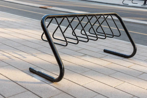 Bike rack for parking bicycles in the street of downtown of Ottawa, Canada. Bycycle stand on pavement near road in the city.