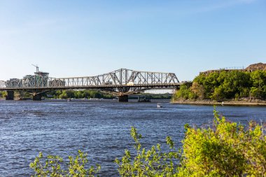 Kanada, Ottawa - 23 Mayıs 2021: Güneşli bir yaz gününde Ottawa Nehri ve Alexandra Köprüsü 'nün Ottawa' dan Gatineau şehrine manzarası