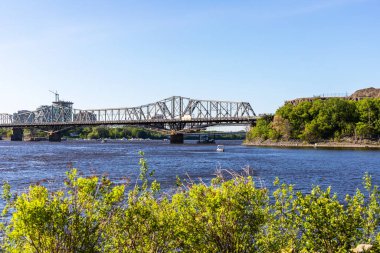 Kanada, Ottawa - 23 Mayıs 2021: Güneşli bir yaz gününde Ottawa Nehri ve Alexandra Köprüsü 'nün Ottawa' dan Gatineau şehrine manzarası