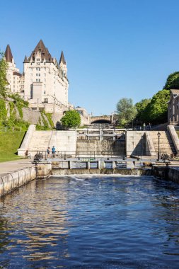 Rideau Canal locks and luxury Fairmont Chateau Laurier hotel in Ottawa, Canada on a sunny day.
