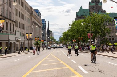 Ottawa, Kanada - 1 Temmuz 2021: Wellington sokak manzarası Ottawa şehir merkezinde yürüyen insanlar ve polis memurlarıyla birlikte. Kanada tatili boyunca arabalar için yollar kapalı..