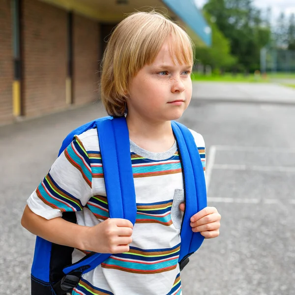 学校の校舎の近くの美しい少年 青いバックパックを持っている小さな金髪の学生 コピースペース付きの学校の概念に戻る — ストック写真