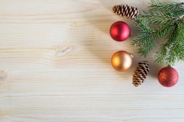 Christmas holiday decorations on wooden table background with copy space. Fir tree branch and small gold and red decorative balls