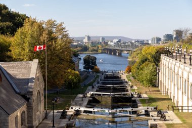 Ottawa, Kanada - 6 Ekim 2025: Rideau Kanalı, sonbahar sezonunda su kilitleri ve Kanada bayrağı. Ottawa Nehri ve Quebec 'teki Gatineau manzarası