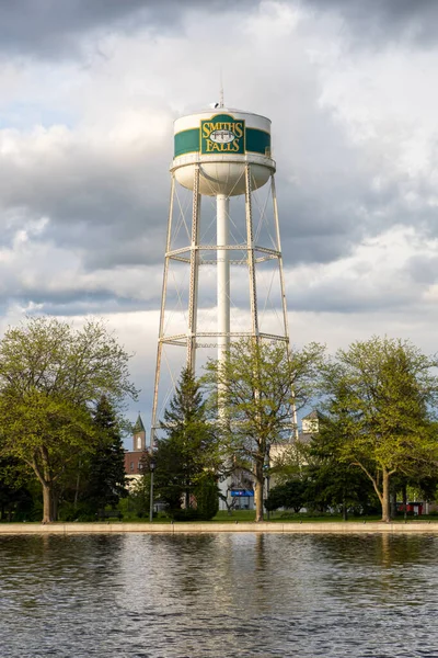 Smiths Falls, Kanada - 25 Mayıs 2025: Nehrin karşısındaki Smiths Falls su kulesinin manzarası. Ontario 'da küçük bir kasaba.