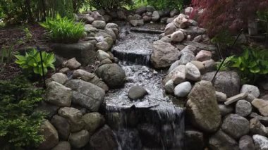 Bahçe şelalesi, taşlar ve süs bitkileri. Kanada, Ottawa 'daki Süs Bahçeleri