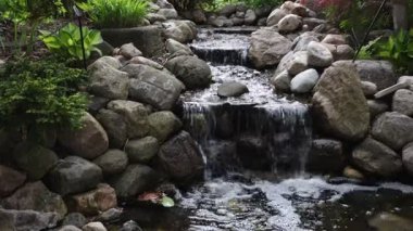 Ottawa, Kanada 'daki Süs Bahçeleri' nde taştan dereler ve yemyeşil yeşilliklerle dekoratif bahçe şelalesi..