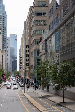 Montreal, Kanada - 4 Temmuz 2025: Eaton binası işlek şehir merkezi, tarihi bir yer ve alışveriş merkezi. Bisiklet yolu ve trafiği olan şehir manzarası