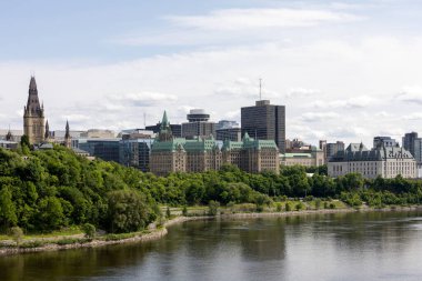 Ottawa Nehri kıyısı boyunca tarihi hükümet binaları. Parliament Hill, Confederation Building ve Kanada Yüksek Mahkemesi ile Ottawa silueti