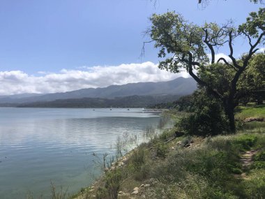 Sakin bir gölün yanında sakin bir manzara beliriyor, dalgalar kıyıya vuruyor. Yemyeşil ağaçlar ve tepeler bölgeyi çevreleyerek hareketli dünyadan barışçıl bir kaçış sağlıyor..