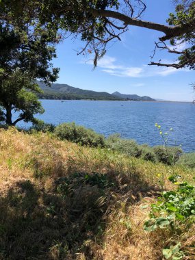 Berrak bir gökyüzünün altında uzanan sakin bir göl yemyeşil ve uzak tepelerle çevrili. Huzurlu bir yansıma ve doğa keşiflerine davetiye çıkarıyor..