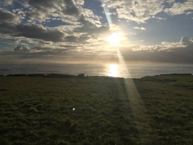 Güneş batmaya başladığında, altın ışınlar okyanusu aydınlatırken bulutlar da yavaşça sürüklenir. Huzurlu manzara huzurlu bir kaçış sunuyor. Düşünmek ve takdir etmek için mükemmel..