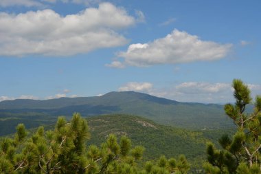 Nefes kesici bir manzara geniş bir dağ manzarasını gözler önüne seriyor. Tüylü bulutlar mavi gökyüzünde süzülürken yemyeşil ağaçlar tepeleri kaplıyor. Doğanın güzelliği tüm gözler önünde, davetkar bir keşif..