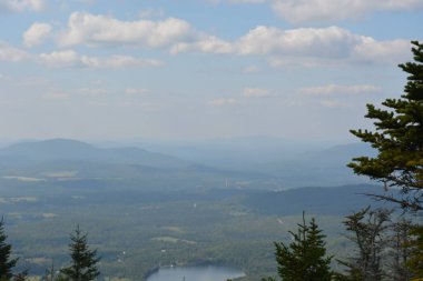Nefes kesen bir manzara, dingin bir göl üzerinde kabarık bulutlarla kaynaşan dağ katmanlarıyla gözler önüne seriliyor. Doğanın huzuru tefekküre ve maceraya davet eder, huşu uyandırır..
