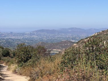 Çarpıcı bir manzara, açık mavi gökyüzünün altındaki yemyeşil ve uzak dağları gözler önüne seriyor. Doğa tepelerde rüzgarı takip eder, keşif ve maceraya davetiye çıkarır..