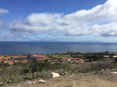 Nefes kesici bir sahil manzarası yamaçta yuva yapmış renkli evlere sahiptir. Sakin okyanus uzanıyor, yumuşak dalgalar ve yumuşak bulutlar üzerinde barışçıl bir atmosfer yaratıyor..