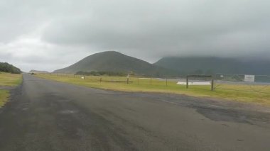 Yağmur bulutlu bir günde, Lord Howe Adası 'ndan geçerek Lagoon Yolu' nda ilerliyoruz.