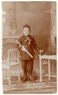 A vintage photo shows young boy - the first holy communion. Antique black & white photo with sepia tint. clipart