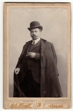 Vintage kabin kartı dandy adam melon şapka, lüks elbise giyer ve baston ve puro tutar gösterilir. Antik siyah ve beyaz fotoğraf.