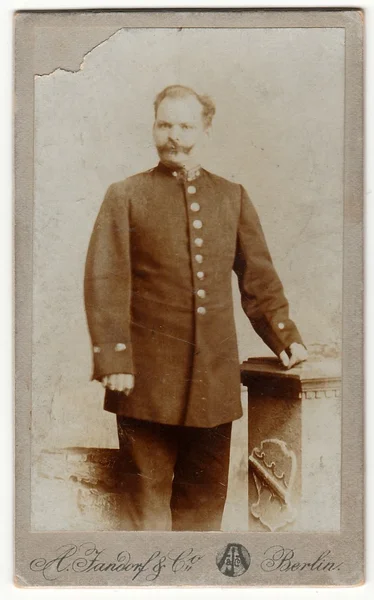 Cartão de armário vintage mostra homem usa um uniforme de carteiro. Foto em preto & branco antigo . — Fotografia de Stock