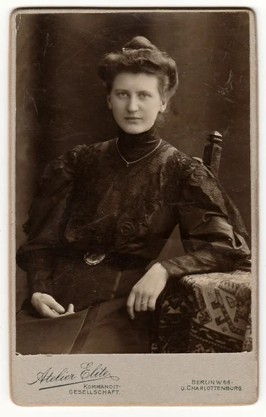 La carte d'armoire vintage montre une femme avec une coiffure victorienne et édouardienne assise à la table. Photo antique noir & blanc . — Photo