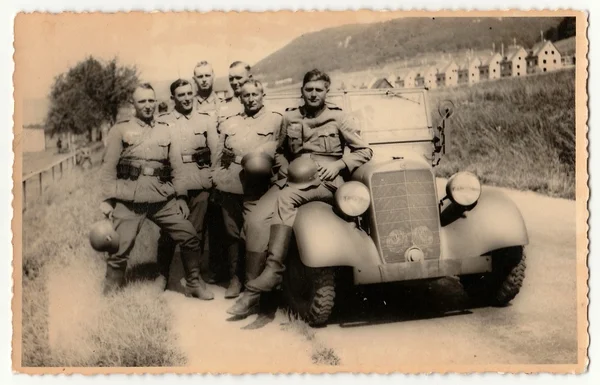 Vintage photo shows German Nazi soldiers stand at convertible. — Stock Photo, Image