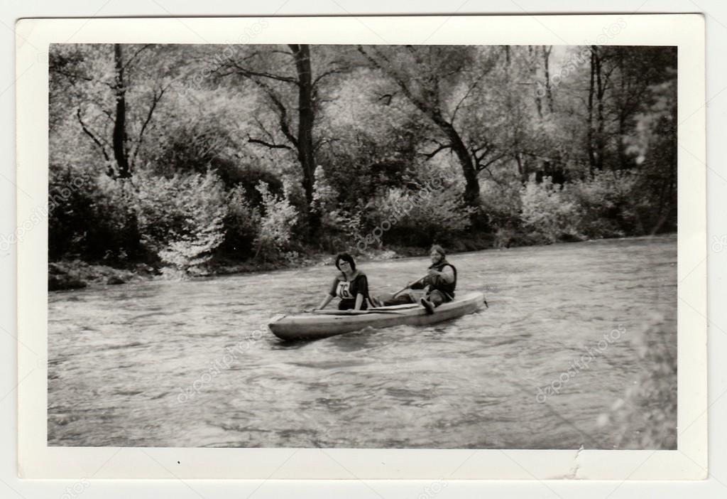 Vintage photo shows young canoeists on the river.