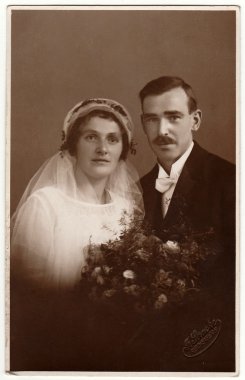 Yeni evlilerin vintage fotoğraf. Gelin peçe takıyor. Siyah ve beyaz antika stüdyo portresi.