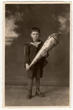 Vintage fotoğraf okul konisi ile öğrenci çocuk gösterir. Sepya tonu ile stüdyo fotoğrafı.