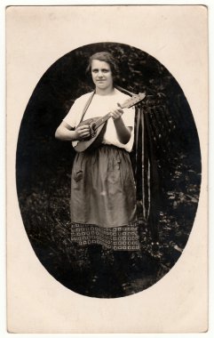 Vintage fotoğraf bir kadın açık havada mandolin oynar gösterir. Fotoğraf oval şeklidir. Siyah ve beyaz antika fotoğraf.