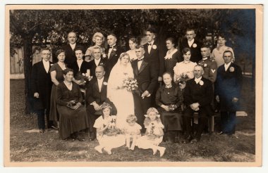 Vintage fotoğraf düğün konukları ile yeni evligösterir. Fotoğraf yaz bahçesinde çekildi. Siyah ve beyaz fotoğraf.