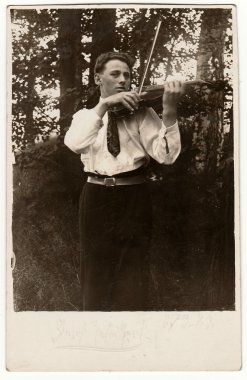 Vintage fotoğraf genç adam açık havada keman çalar gösterir. Antika siyah ve beyaz fotoğraf.