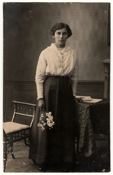 Vintage photo shows woman holds the flowers.  Black & white studio photo with sepia tint. — Stock Photo, Image