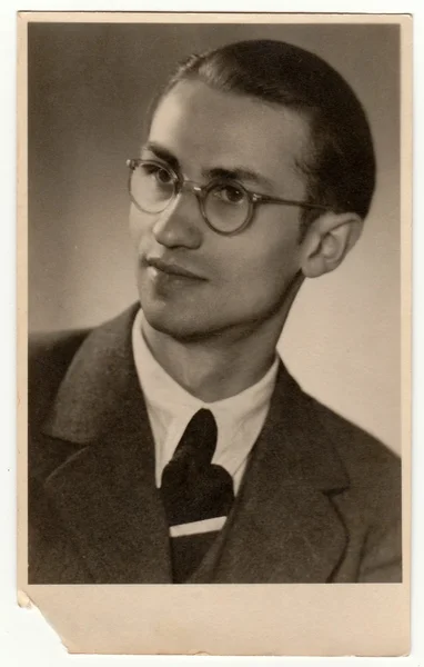 Vintage photo shows young man with glasses. Black & white antique studio portrait. — Stock Photo, Image