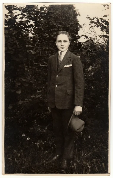 Vintage-Foto zeigt Mann trägt Anzug mit elegantem Hut posiert im Freien. Schwarz / weiß antikes Foto. — Stockfoto