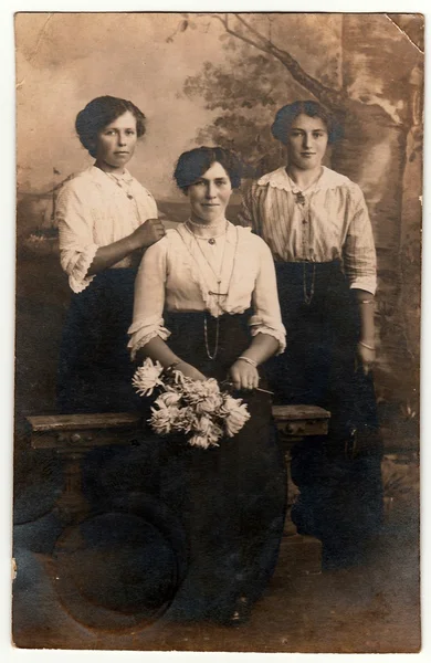 Foto vintage mostra três mulheres posar em um estúdio de fotografia. Retrato de estúdio antigo preto e branco . — Fotografia de Stock