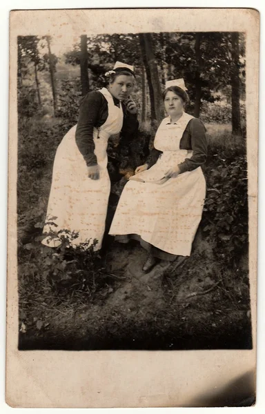 Foto vintage mostra duas enfermeiras ao ar livre. Foto em preto e branco antigo com tonalidade escura obtida durante o processo fotográfico . — Fotografia de Stock
