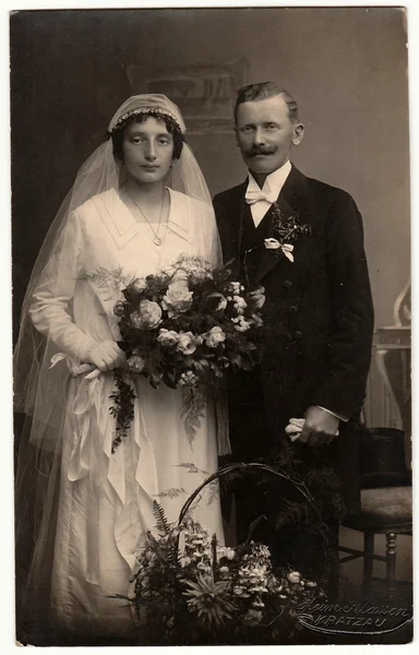 Винтажное фото молодоженов. Невеста носит вуаль и держит свадебный букет. Черно-белый антикварный портрет . — стоковое фото