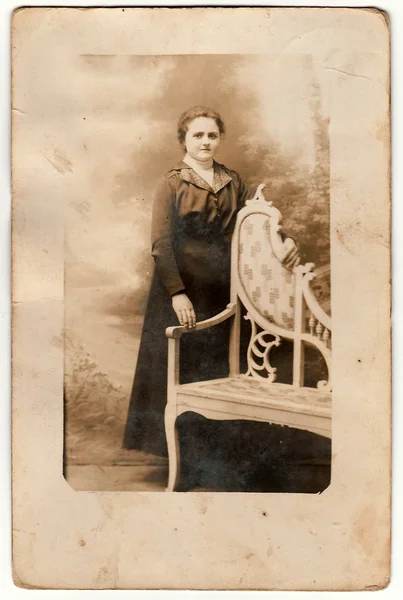 Vintage foto toont een jonge vrouw poses naast historische gesneden Bank. Zwarte & witte antieke fotografie. — Stockfoto