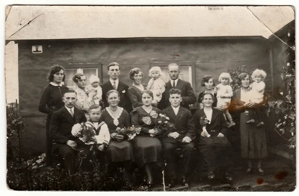 Vintage photo shows a big family poses behind house.  Black & white antique photography. — Stock Photo, Image