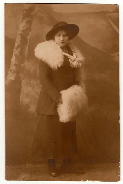 Vintage fotó mutatja a nő visel fehér szőr corral és fehér muff. Egy elegáns nő széles karimájú kalapot visel. — Stock Fotó
