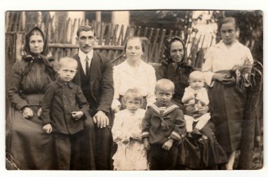 Vintage fotoğraf ahşap çit önünde büyük bir kırsal aile gösterir. Siyah ve beyaz antika fotoğraf.