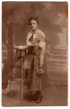 Vintage fotoğraf genç bir kadın gül tutar gösterir. Sepya etkisi ile stüdyo fotoğrafçılığı.